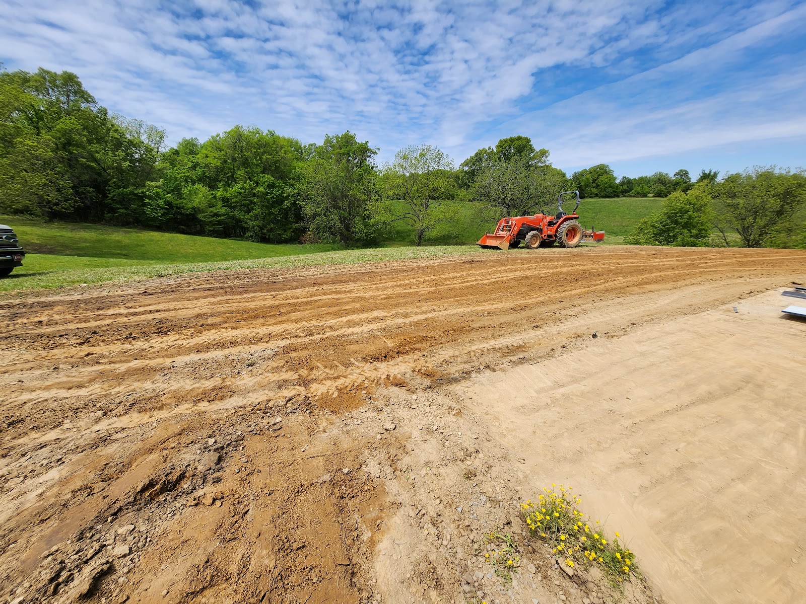 Freshly graded gravel pad with tractor in West Tennessee