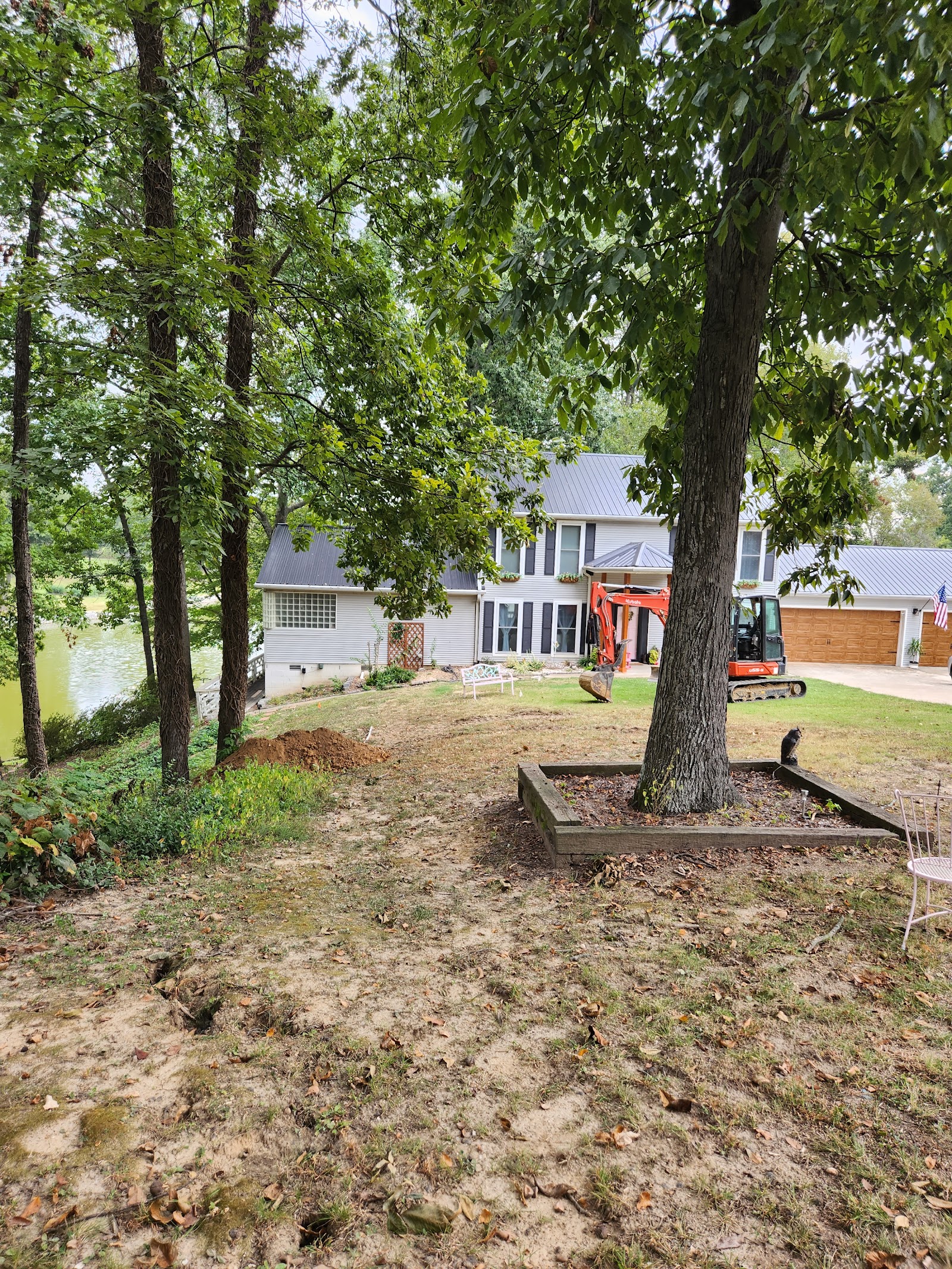 Harris Dirt Works mini excavator working beside a shade tree at a Dyersburg home